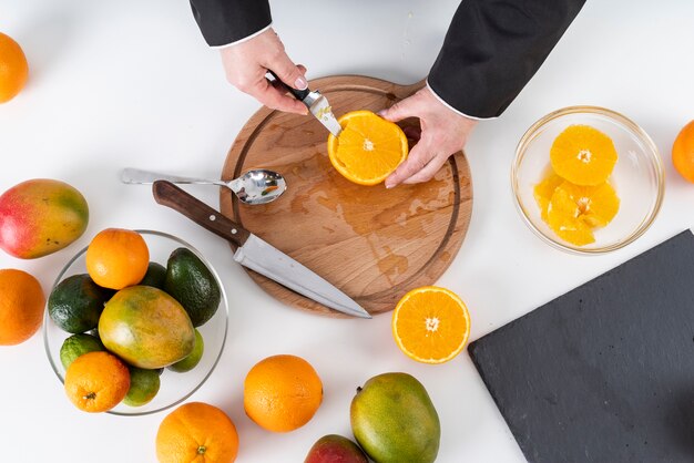 Vista superior del chef cortando una naranja