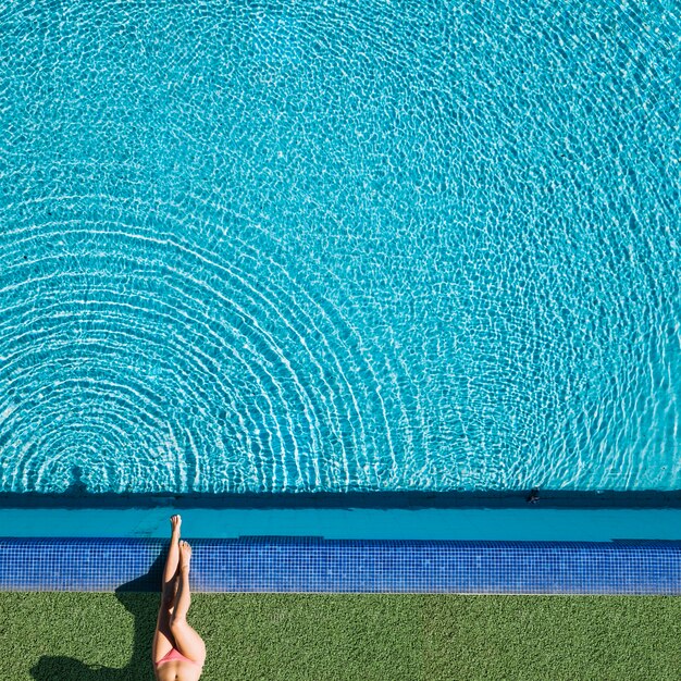 Vista superior de chica relajando al lado de piscina