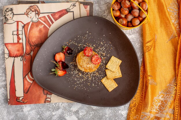 Vista superior de chips salados diseñados con fresas dentro de la placa en la mesa blanca, chips snack fruit berry