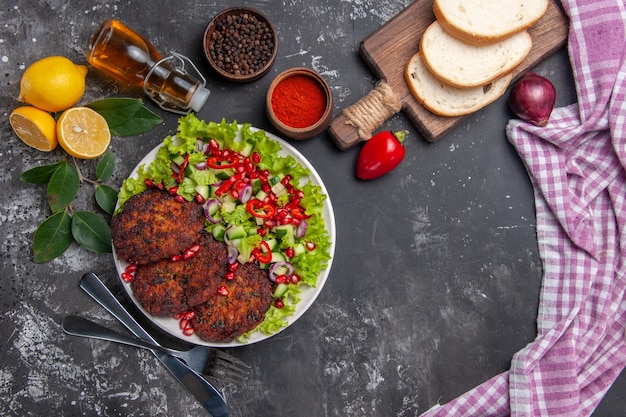 Vista superior de chuletas de carne con ensalada y pan