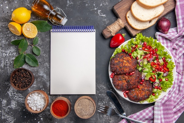 Foto gratuita vista superior de chuletas de carne con ensalada y pan