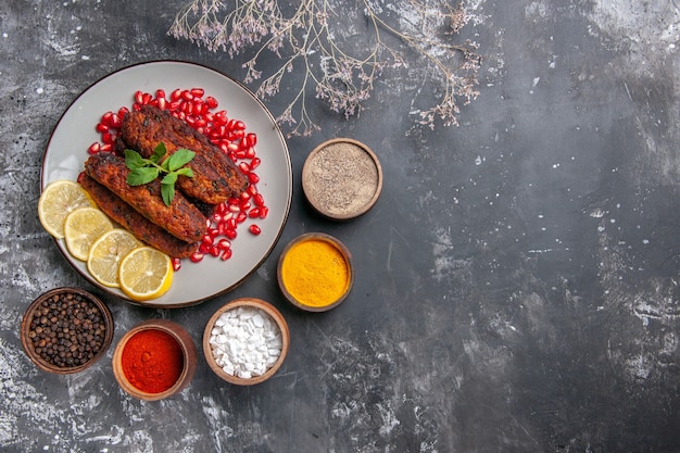 Vista superior chuletas de carne largas con limón y granadas