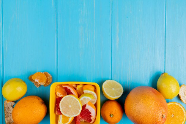 Vista superior de cítricos como mandarina pomelo limón sobre fondo azul con espacio de copia