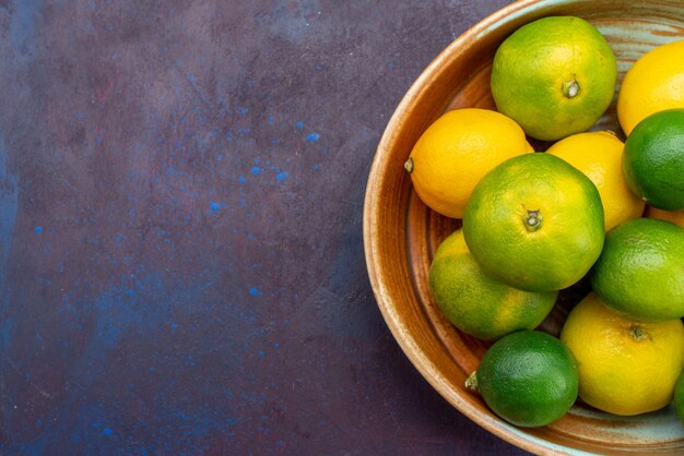 Vista superior cítricos jugosos limones y mandarinas en el escritorio oscuro cítricos naranja exótica fruta agria