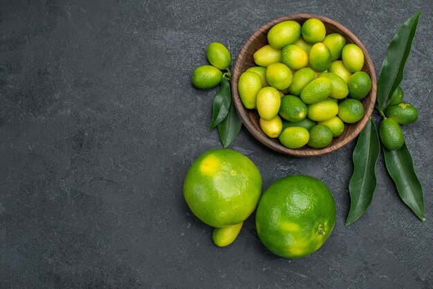 Vista superior de los cítricos tazón de frutas cítricas con hojas de mandarinas