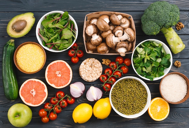 Vista superior de los cítricos; Verduras y legumbres en mesa negra.