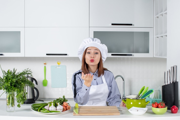 Foto gratuito vista superior de la cocinera y verduras frescas haciendo gesto de beso en la cocina blanca