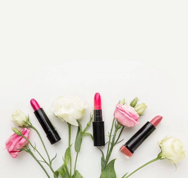 Vista superior colección de lápiz labial y flores con espacio de copia