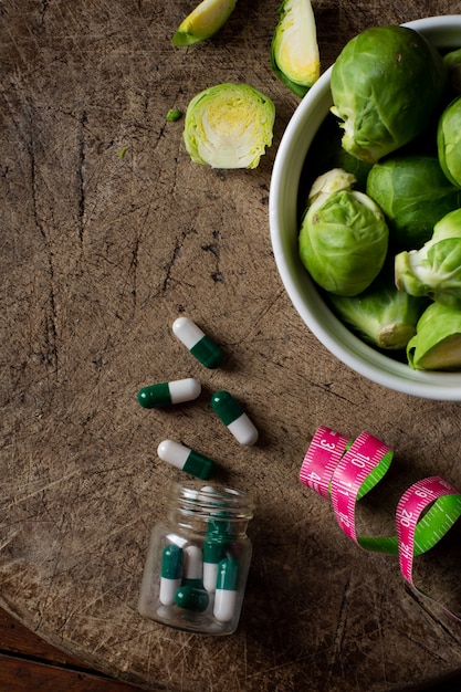 Vista superior de las coles de Bruselas con medicamentos sobre la mesa