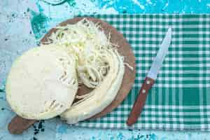 Foto gratuita vista superior de coles frescas en rodajas troceadas y medio entero en un escritorio azul brillante, ensalada saludable de bocadillos de comida vegetal