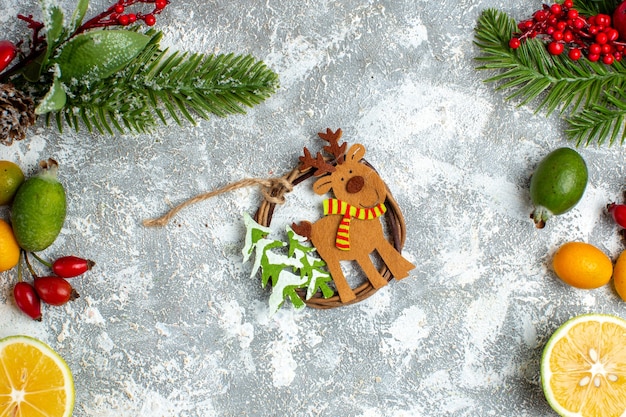 Vista superior colgante de árbol de Navidad cortar limones feijoas ramas de árbol de Navidad en mesa gris