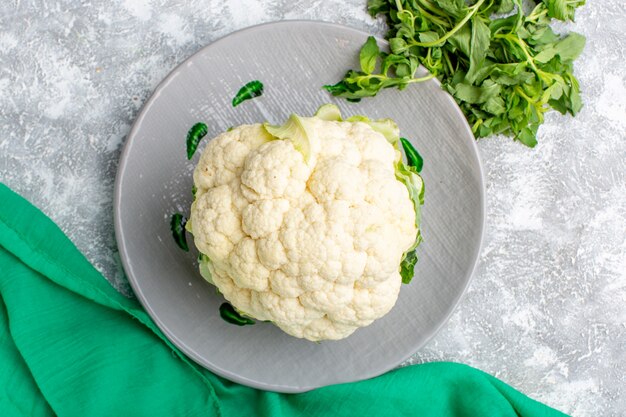 Vista superior de coliflor fresca con verduras en la superficie gris