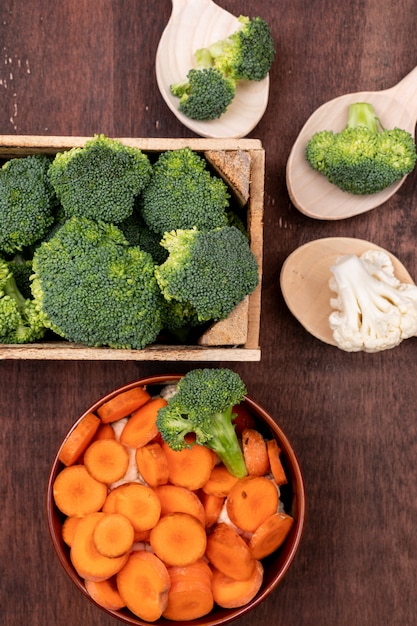 Foto gratuita vista superior de coliflor de zanahoria y brócoli en mesa de madera