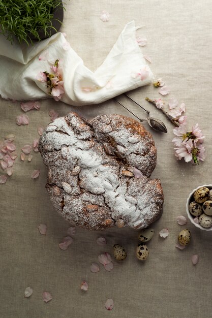 Vista superior colomba con polvo y flores.