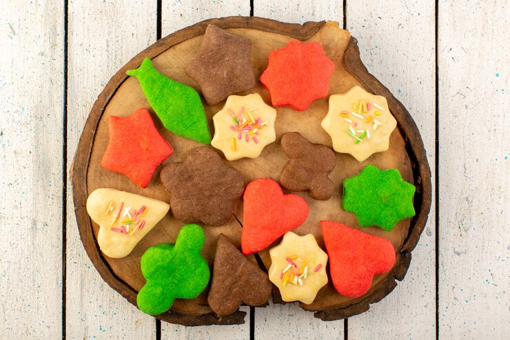 Foto gratuito vista superior de coloridas deliciosas galletas diferentes formadas en el escritorio de madera marrón