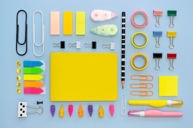 Vista superior de coloridos artículos de papelería de oficina con clips y gomas de borrar
