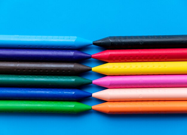 Vista superior coloridos crayones alineados uno frente al otro