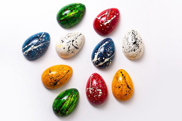 Foto gratuita una vista superior coloridos huevos de chocolate diseñados aislados en la pared blanca