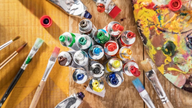 Vista superior de coloridos tubos de pintura con pinceles