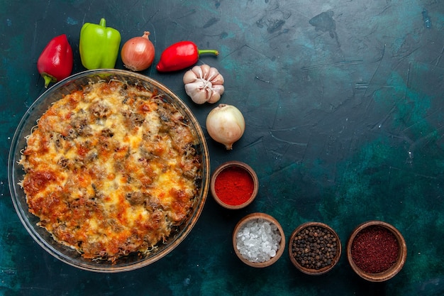 Vista superior de la comida de carne con queso con verduras frescas y condimentos en la cena de verduras de plato de comida de carne de escritorio azul oscuro