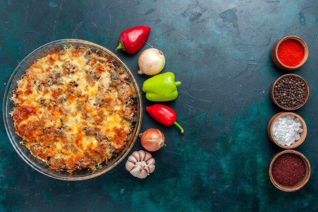 Vista superior de la comida de carne con queso con verduras frescas y condimentos en el escritorio azul oscuro comida plato de comida de carne cena horno hornear