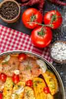 Foto gratuita vista superior de la comida de pollo crudo con patatas, verduras en una cacerola sobre una toalla roja pelada y sal de tomate sobre fondo gris