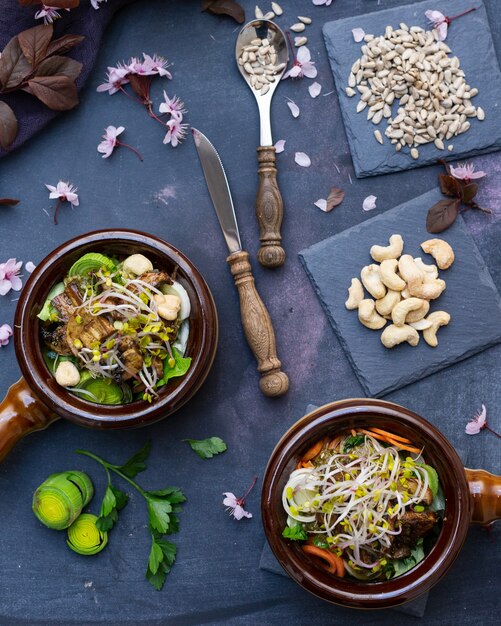 Vista superior de una comida vegana con champiñones, cebollas, zanahorias y puerros