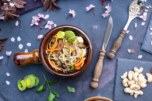 Vista superior de una comida vegana con champiñones, cebollas, zanahorias y puerros