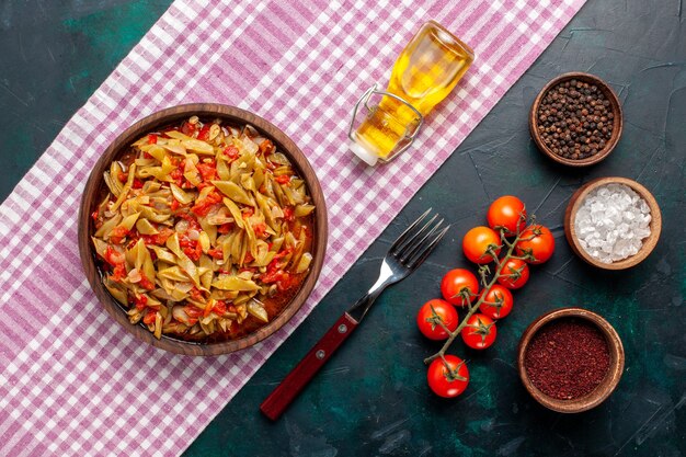 Vista superior de comida vegetal en rodajas con diferentes ingredientes en el escritorio azul oscuro