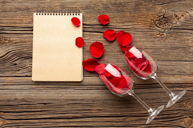 Vista superior composición del día de San Valentín con bloc de notas y pétalos vacíos