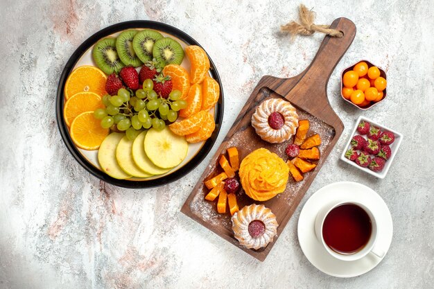 Vista superior composición de diferentes frutas frescas y maduras sobre fondo blanco frutas maduras color suave salud