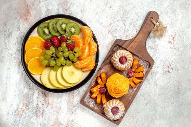 Vista superior composición de diferentes frutas frescas y maduras sobre fondo blanco frutas maduras color suave salud