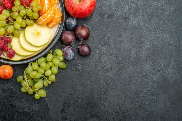 Vista superior de la composición de diferentes frutas frescas y maduras sobre el fondo gris suaves frutas frescas salud madura
