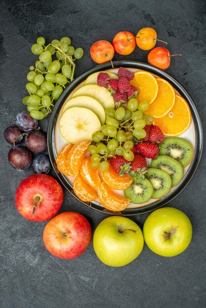 Vista superior de la composición de diferentes frutas frescas y maduras sobre el fondo gris suaves frutas frescas salud madura