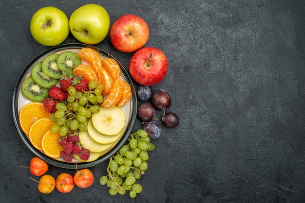 Vista superior composición de diferentes frutas frescas y maduras sobre fondo oscuro salud de frutas frescas suaves
