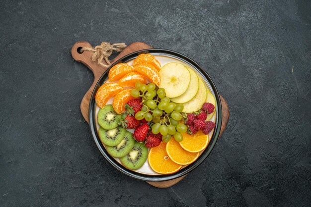 Vista superior de la composición de diferentes frutas frescas en rodajas y maduras sobre fondo gris suaves frutas frescas salud madura
