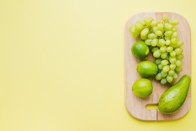 Vista superior de composición con espacio en blanco, tabla de cortar y frutas