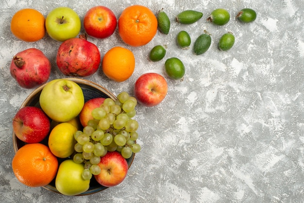 Vista superior de la composición de la fruta feijoa, mandarinas y manzanas sobre el fondo blanco, fruta madura, vitamina mellow fresh