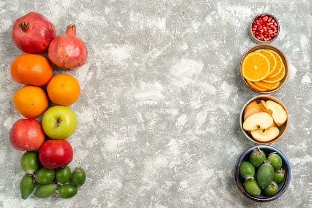 Vista superior de la composición de la fruta feijoa mandarinas y manzanas sobre una superficie blanca fruta vitamina madura suave