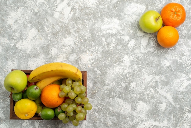Vista superior de la composición de fruta fresca plátanos uvas y feijoa sobre fondo blanco fruta madura vitamina suave salud fresca