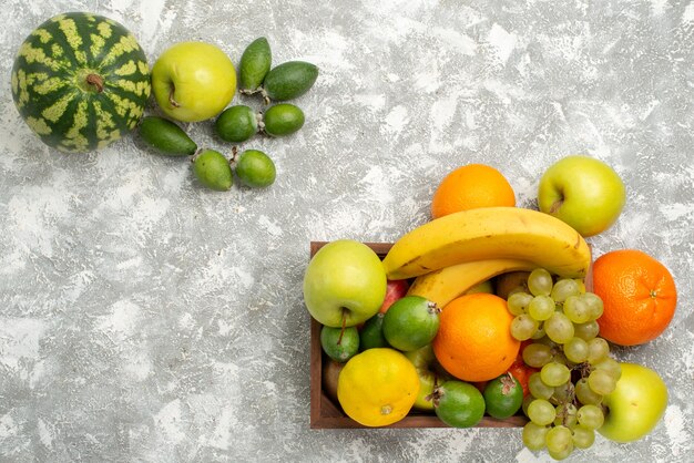 Vista superior de la composición de fruta fresca plátanos uvas y feijoa sobre fondo blanco fruta madura vitamina suave salud fresca