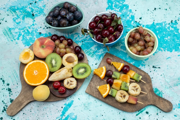 Vista superior de la composición de la fruta en rodajas enteras en el brillante escritorio fruta azúcar de galleta exótica