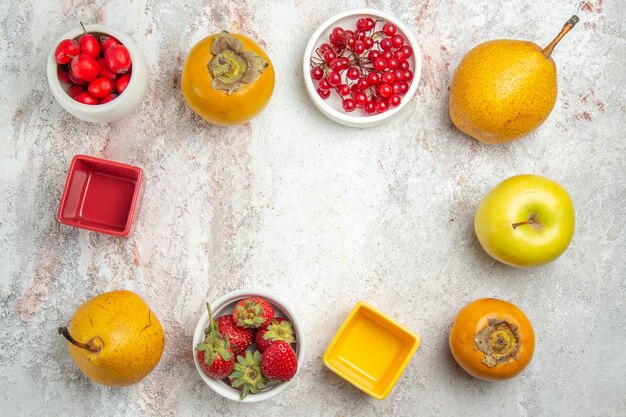 Vista superior de la composición de frutas diferentes frutas frescas en el color de la mesa blanca madura