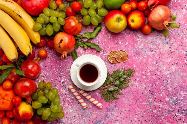 Foto gratuita vista superior de la composición de frutas frescas frutas coloridas con taza de té en la superficie rosa