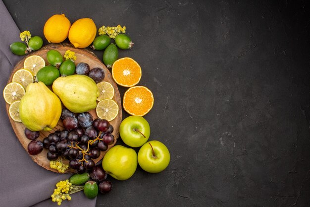 Vista superior de la composición de frutas frescas frutas maduras en frutas de superficie oscura suave vitamina fresca madura