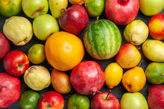 Vista superior de la composición de frutas frescas manzanas, peras y mandarinas en el escritorio de color azul oscuro de frutas maduras de color de árboles frescos muchos suaves