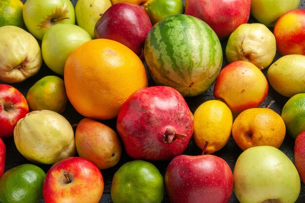 Vista superior de la composición de frutas frescas manzanas, peras y mandarinas en el escritorio de color azul oscuro de frutas maduras de color de árboles frescos muchos suaves