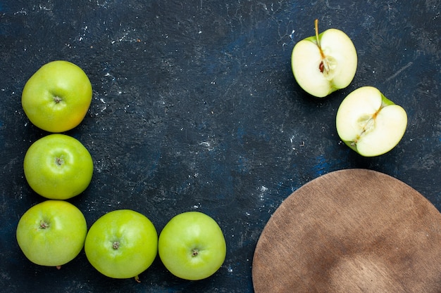 Vista superior de la composición de manzanas verdes frescas con medio corte en rodajas forrado en oscuro, fruta fresca madura suave