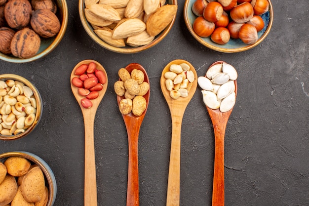 Vista superior de la composición de la nuez con diferentes nueces frescas sobre una superficie oscura