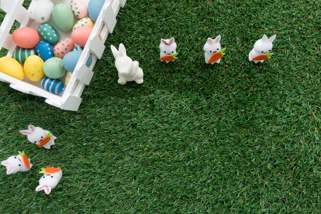 Vista superior de composición de pascua con cerca, conejos y huevos